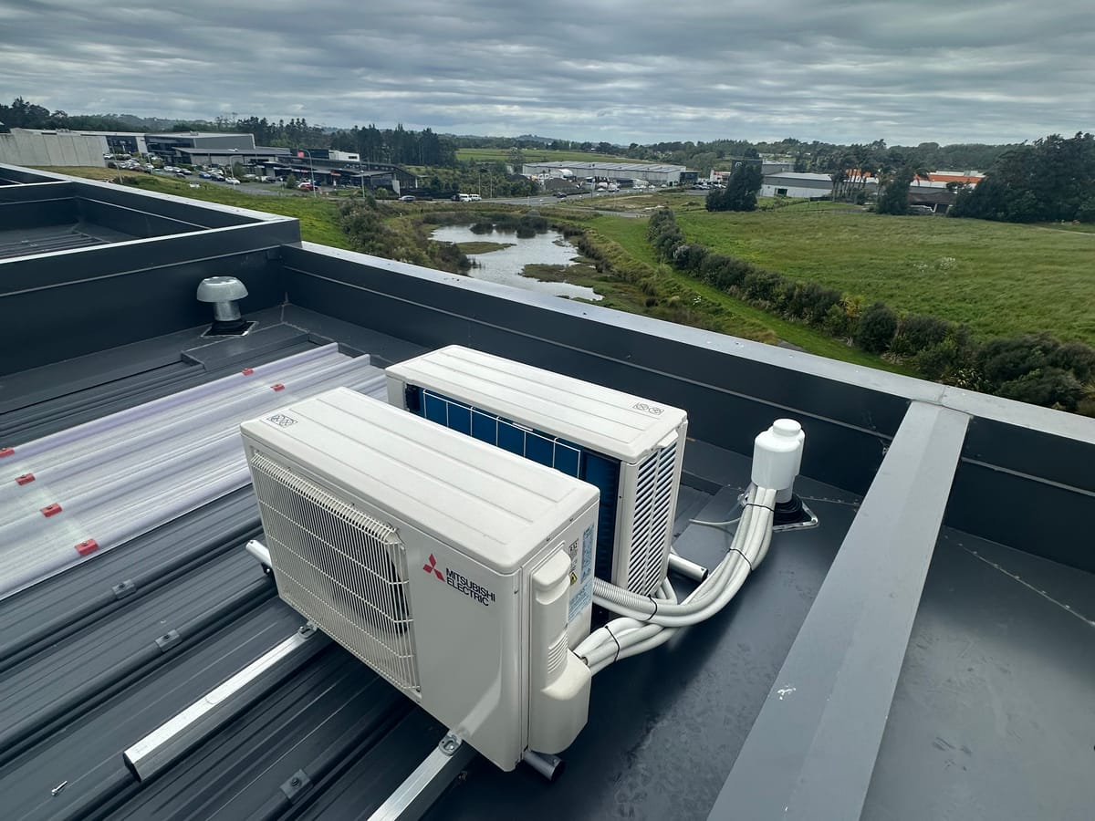 Twin Mitsubishi Electric heat pumps installed on a commercial rooftop, Auckland.