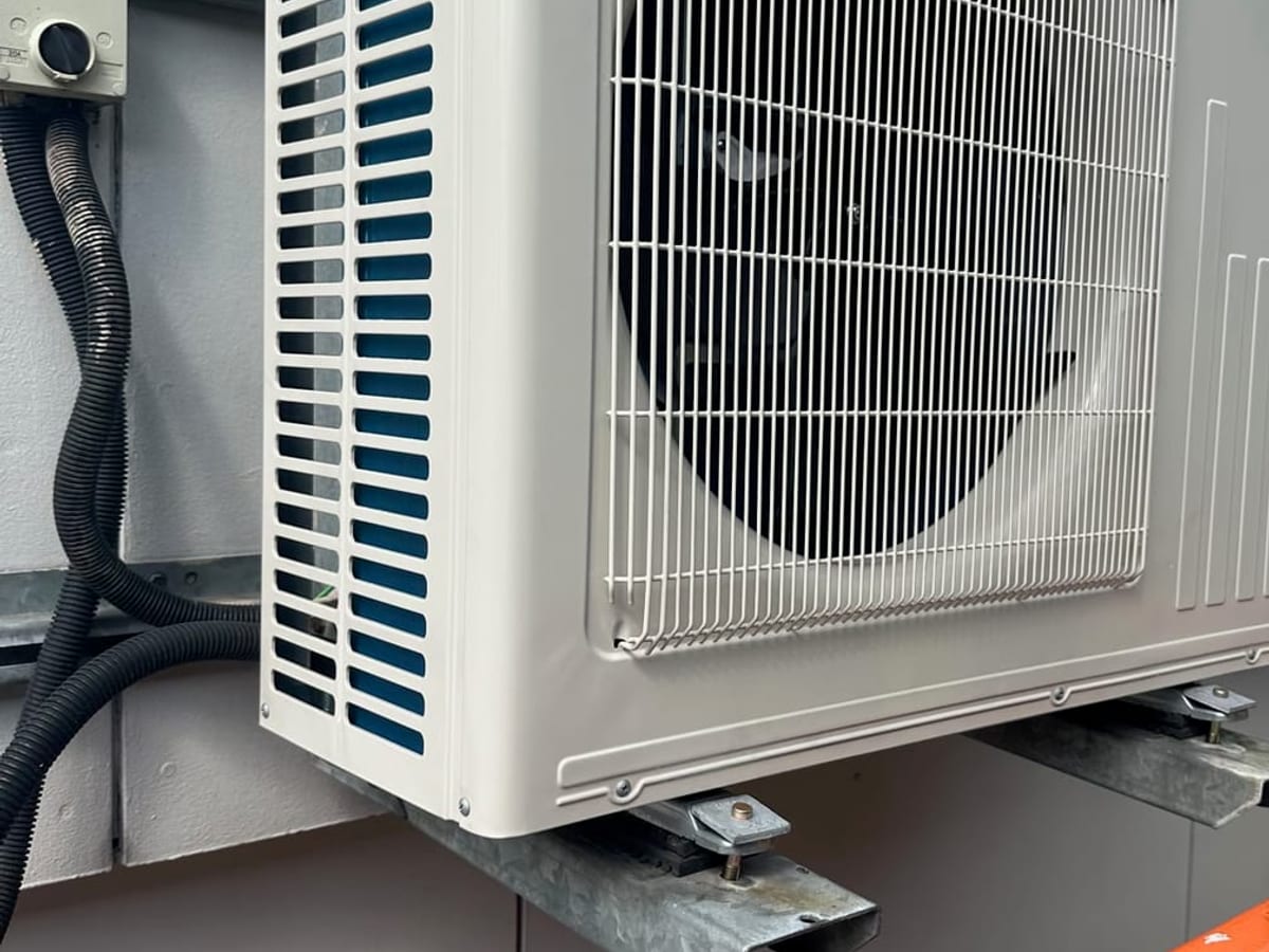 Mitsubishi Electric outdoor unit, neatly bracket-mounted and commissioned.